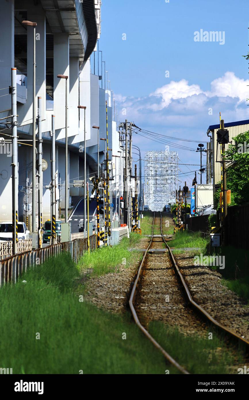 japanische Landschaft gerade Güterzuggleise durch das Industriegebiet Kawasaki mit blauem Sommerhimmel Stockfoto