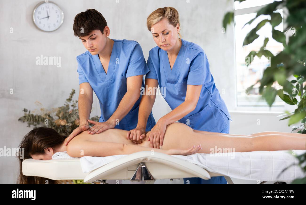 Professioneller Masseur, der dem Auszubildenden Massagetechniken beibringt Stockfoto