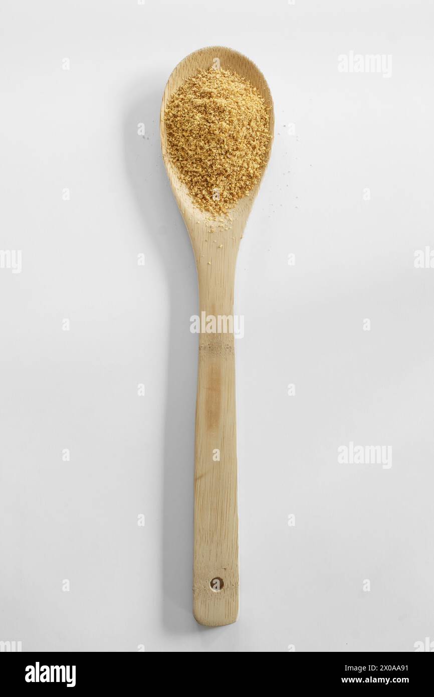 Goldener gerösteter Flachs und Holzlöffel auf weiß Stockfoto