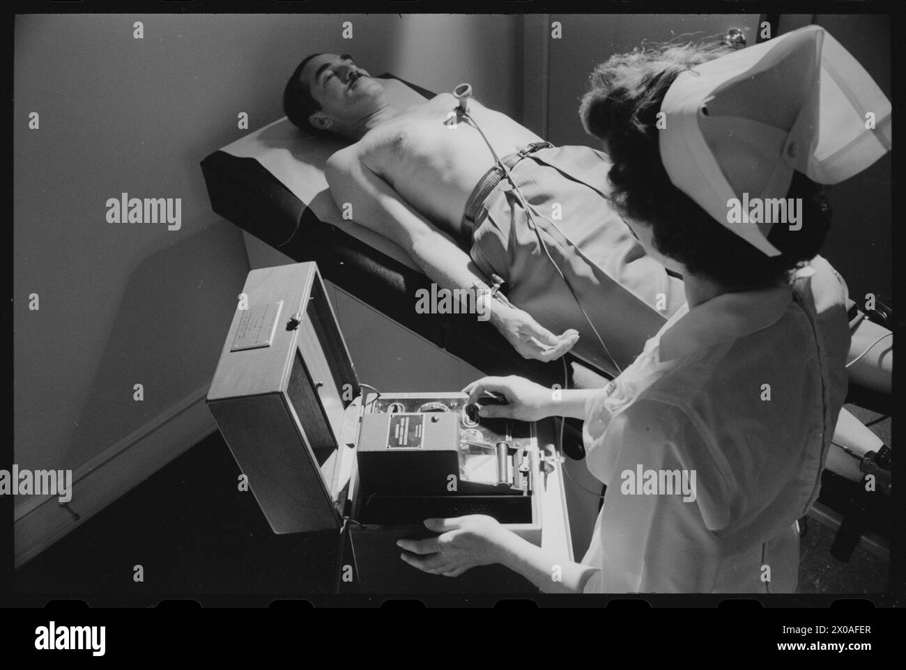 Krankenschwester, die ein Elektrokardiogramm bei männlichem Patienten macht, kein Ort, 30. Oktober 1958. (Foto: Warren K Leffler/US News and World Report Collection) Stockfoto