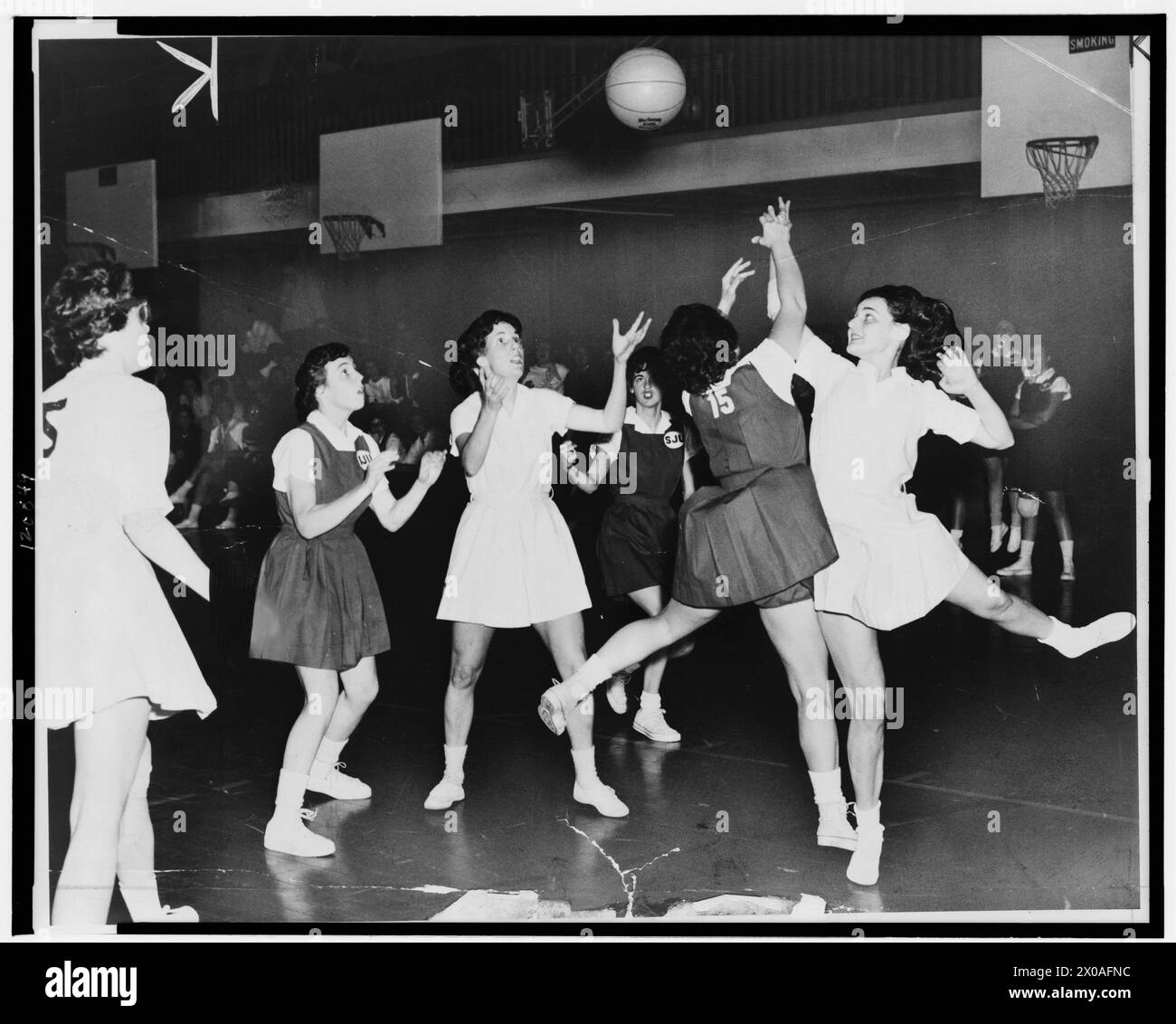 Sue Kelly, ganz rechts in weiß, und Ann Santorelli (15) von der St Johns University kämpfen um den Rückschlag bei einem Basketballspiel für Frauen in New York, New York, um 1961. (Foto: William C Greene/New York World-Telegram and the Sun Newspaper Photograph Collection) Stockfoto