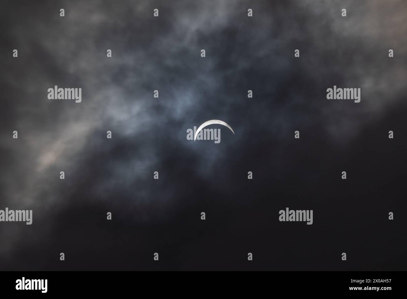 Partielle Sonnenfinsternis - Mond bedeckt Sonne, dunkle Wolken, himmlisches Drama - Halbmondsonne - atmosphärische Stimmung. Aufgenommen in Toronto, Kanada. Stockfoto