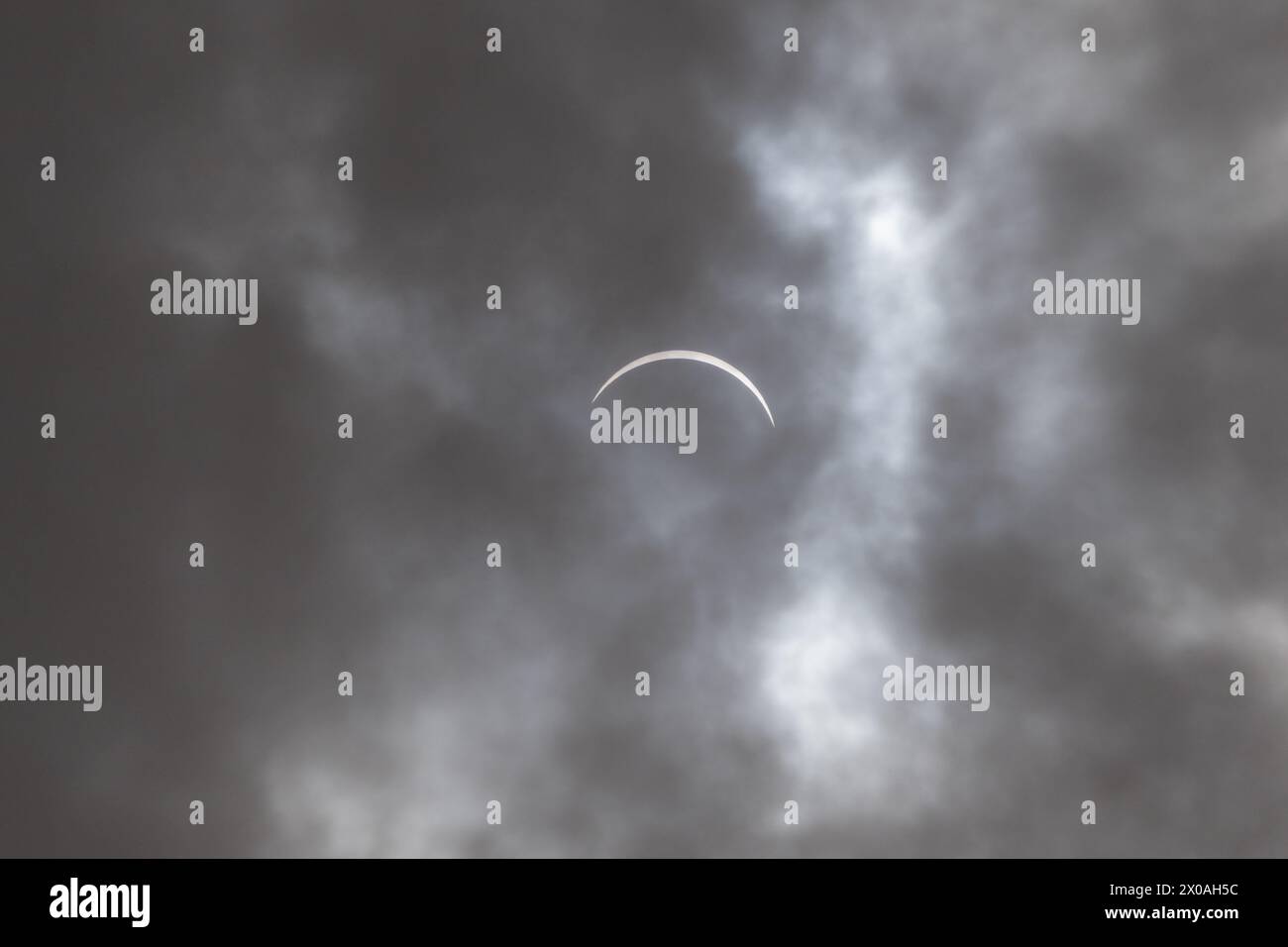 Partielle Sonnenfinsternis - Mond bedeckt Sonne, dunkle Wolken, himmlisches Drama - Halbmondsonne - atmosphärische Stimmung. Aufgenommen in Toronto, Kanada. Stockfoto