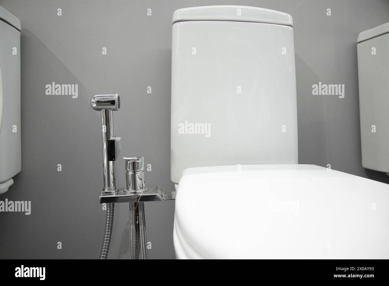 Toilettenschüssel mit Bidet-Duschkopf in einem Haushaltswarenladen. Weichzeichner Stockfoto