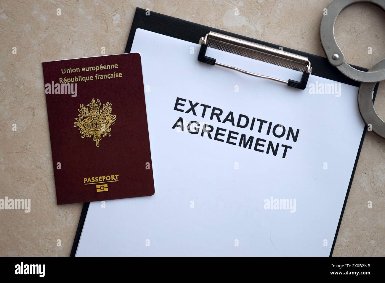 Pass von Frankreich und Auslieferungsabkommen mit Handschellen auf dem Tisch in Nahaufnahme Stockfoto