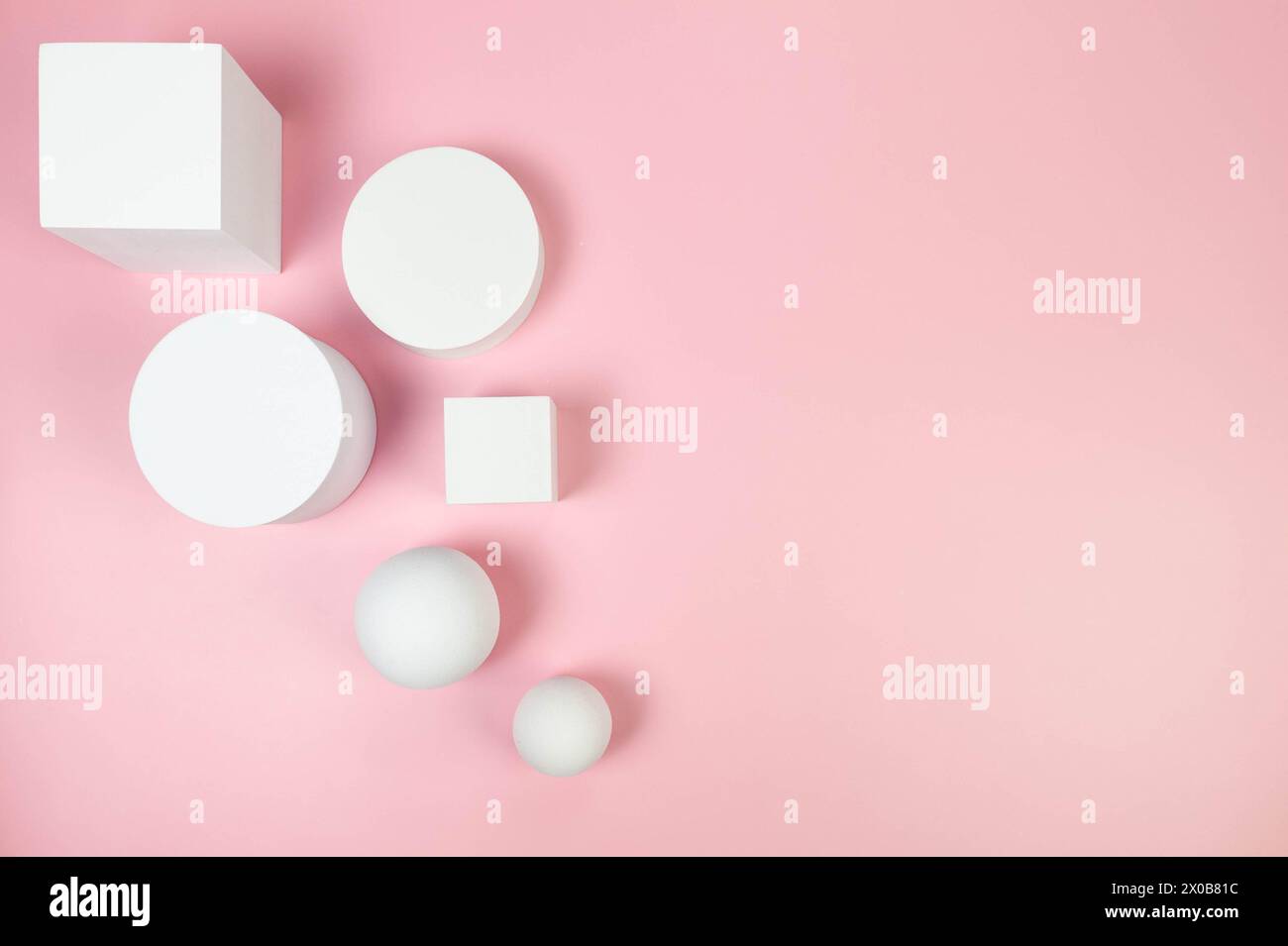 Blick von oben auf weiße runde Podeste, Quadrate, weiße Kugeln auf rosa Hintergrund. Geometrische abstrakte Formen für die kosmetische Produktpräsentation. Stockfoto