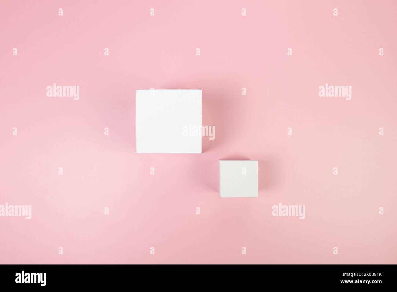 Draufsicht von zwei weißen quadratischen Podesten auf rosa Hintergrund. Geometrische abstrakte Formen für die kosmetische Produktpräsentation. Flache Ladefläche, Kopierraum. Stockfoto