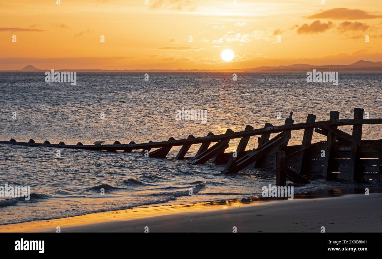 Portobello, Edinburgh, Schottland, Großbritannien. 11. April 2024. Sonnenaufgang am Firth of Forth mit milder Temperatur von 13 Grad Celsius. Nach 10 Tagen Rekordniederschlag in Edinburgh von etwa 80 bis 90 mm Regen ist die Sonne am frühen Morgen willkommen. Quelle: Arch White/Alamy Live News. Stockfoto