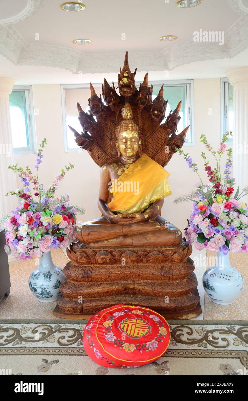 Schnitzerei Holz Buddha meditieren schützender Deckkopf durch mythische Schlange oder Nak Prok von Wat Huay Pla Kang Tempel für thailänder Reise Besuch Respekt PR Stockfoto