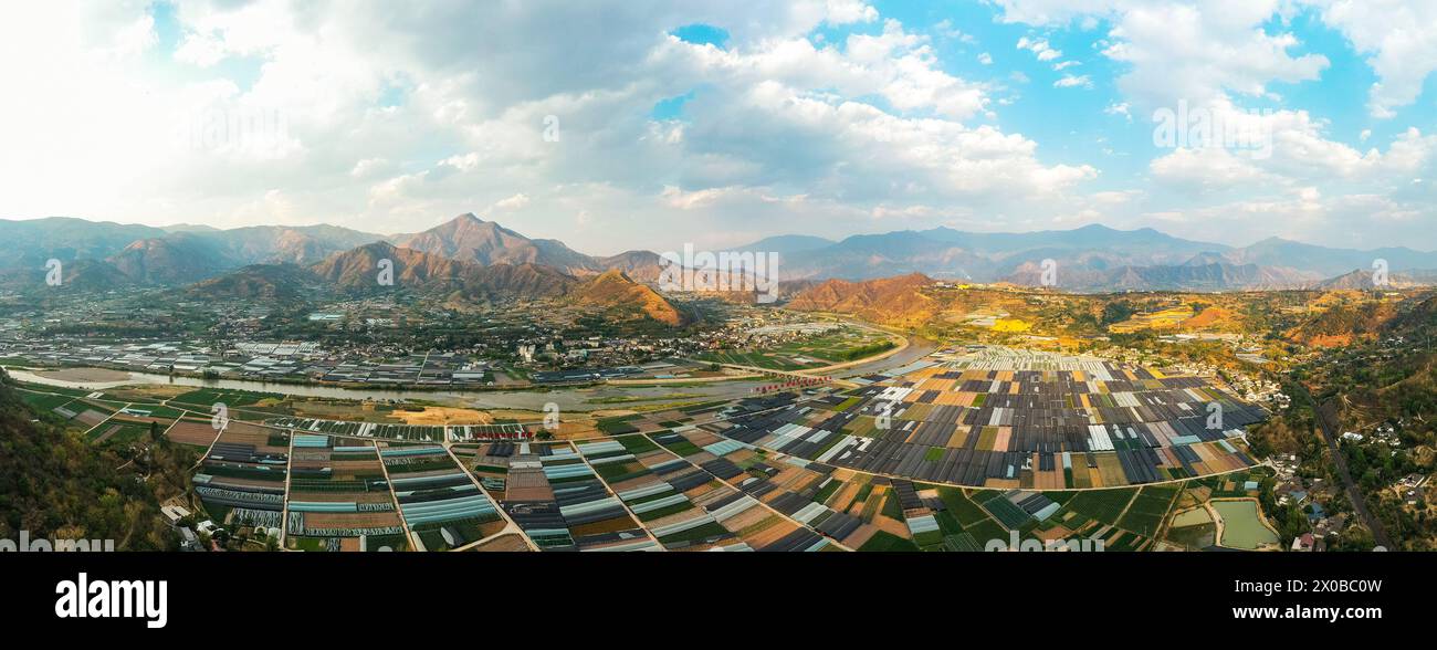 (240411) -- PEKING, 11. April 2024 (Xinhua) -- ein Luftdrohnenfoto vom 8. April 2024 zeigt einen Industriepark mit Plantagen mit Pflanzen und Gemüse im Landkreis Miyi, südwestchinesische Provinz Sichuan. Die Anning River Ebene, die vom Anning River gezüchtet wird, ist die zweitgrößte Ebene im Südwesten Sichuans. Sie bildet mit ihren einzigartigen natürlichen Bedingungen wie Wasser, Boden, Licht und Klima eine günstige Grundlage für die landwirtschaftliche Entwicklung. Das Miyi County der Stadt Panzhihua, das am Fluss Anning liegt, ist eines der ersten Grafschaften in China, in denen ein nationaler Agrarsektor gebaut wurde Stockfoto