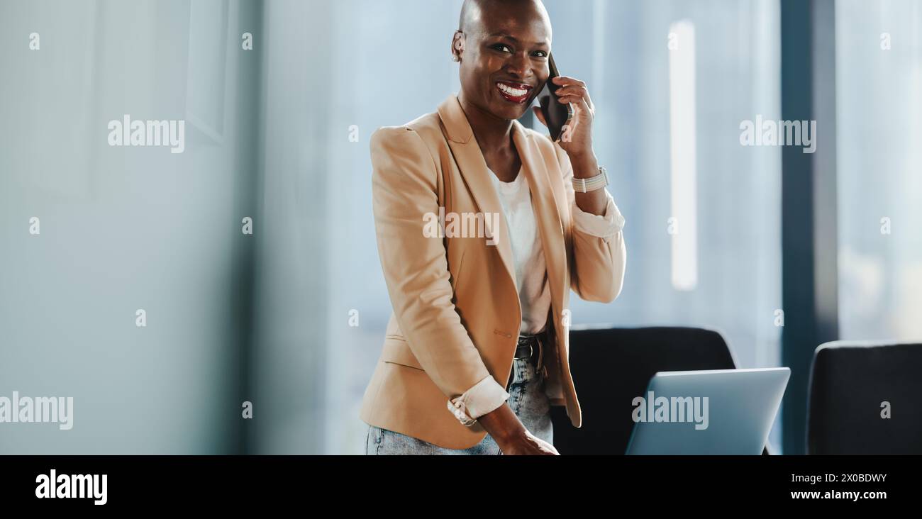 Selbstbewusste Geschäftsfrau in ihrem Büro, die mit dem Smartphone telefoniert. Sie sieht glücklich und professionell aus und spricht mit Erfolg. Ein reifer Unternehmer Stockfoto