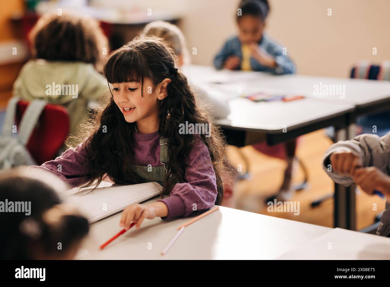 Eine Grundschulschülerin sitzt an ihrem Schreibtisch und macht ihre Schularbeit. Mädchenschulung in einem Co-Ed-Kinderentwicklungszentrum. Stockfoto