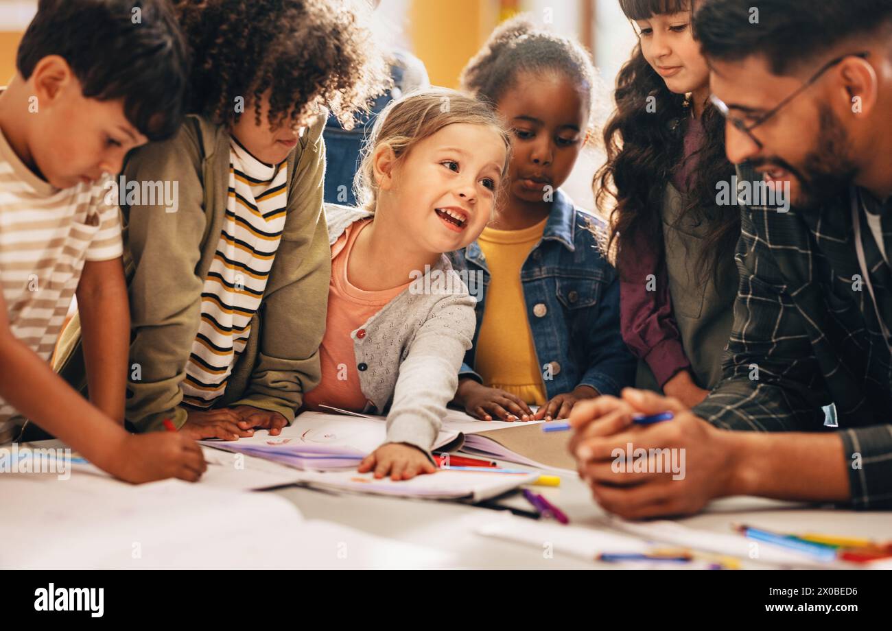 Gruppenarbeit in einer Grundschulklasse. Lehrer, der seinen Schülern beibringt, wie man in einer Kunststunde zeichnet. Entwicklung der Kreativität von Kindern bei elementary le Stockfoto