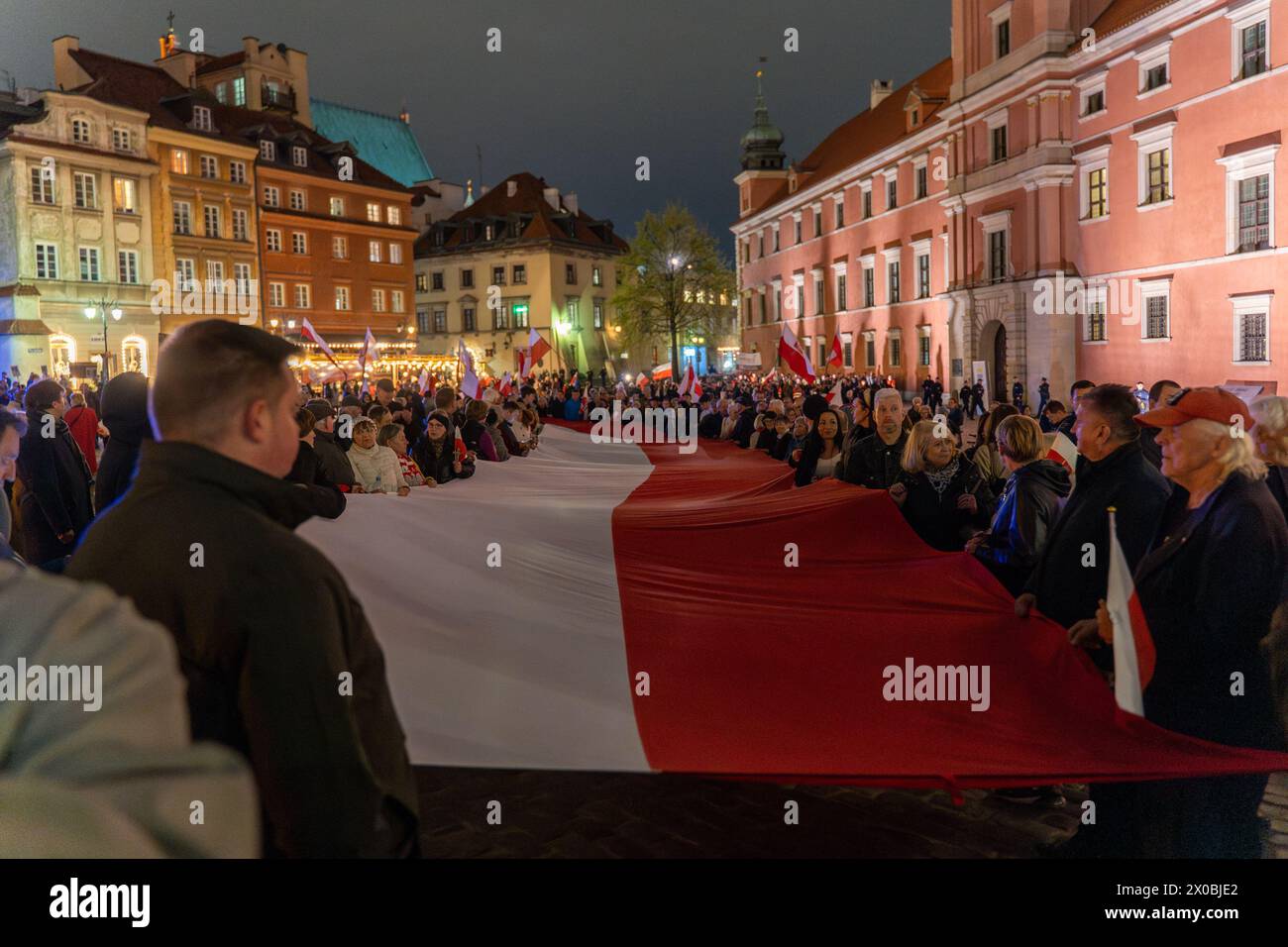 Die Demonstranten tragen eine lange polnische Flagge während des Gedenkmarsches an die Opfer der Smolensk-Katastrophe. Am 14. Jahrestag der Smolensk-Luftkatastrophe nahmen etwa 2.000 Menschen am Gedenkmarsch an die Opfer der Smolensk-Katastrophe Teil. Während ihrer Teilnahme an der Demonstration riefen sie, dass diese Katastrophe ein Angriff sei. Bei der Smolensk-Flugzeugkatastrophe stürzte ein Tupolev Tu-154-Flugzeug auf dem polnischen Luftwaffenflug 101 in der Nähe der russischen Stadt Smolensk ab. (Foto: Marek Antoni Iwanczuk / SOPA Images/SIPA USA) Stockfoto