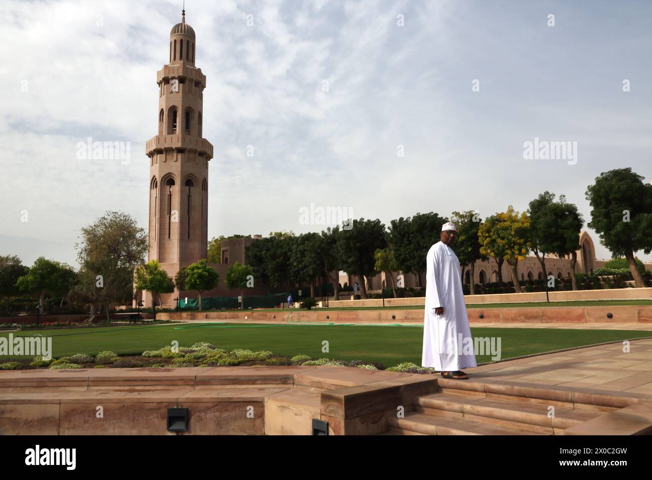 Sultan Qaboos große Moschee Omani mit Dishdasha und Kummah Standing in the Garden von Minaret Muscat Oman Stockfoto