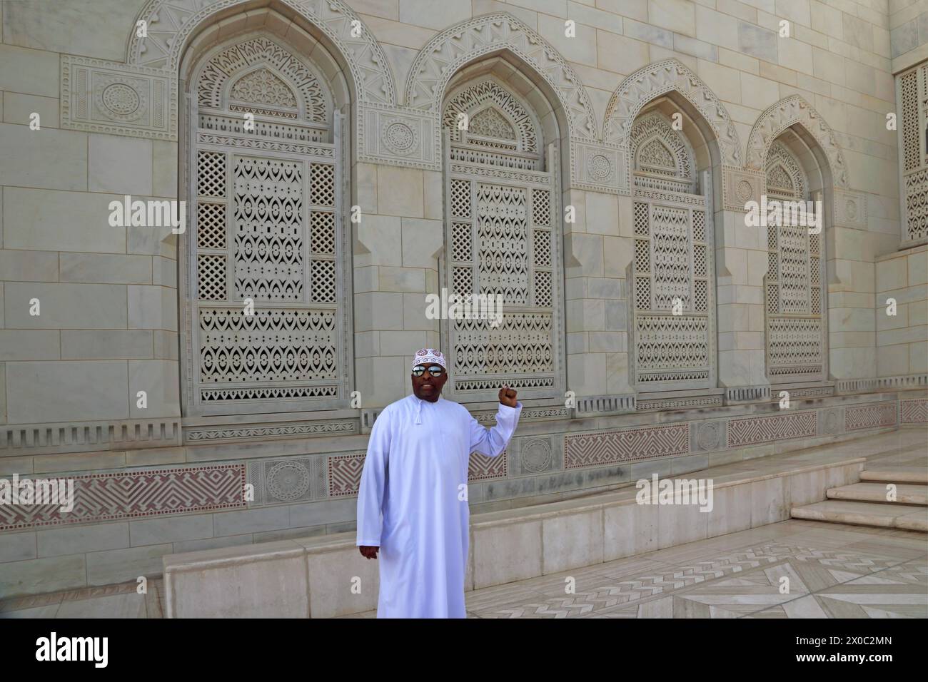 Sultan Qaboos große Moschee Omani mit Dishdasha und Kummah stehend bei verzierten Windows Muscat Oman Stockfoto