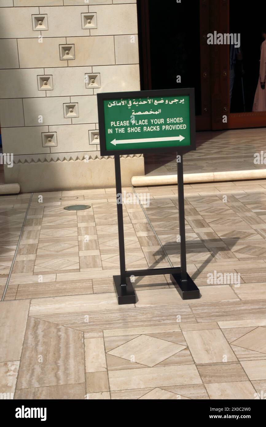Sultan Qaboos Grand Moschee hölzernes kunstvolles zweisprachiges Schild „Bitte legen Sie Ihre Schuhe in die Schuhregale bereit“ Muscat Oman Stockfoto