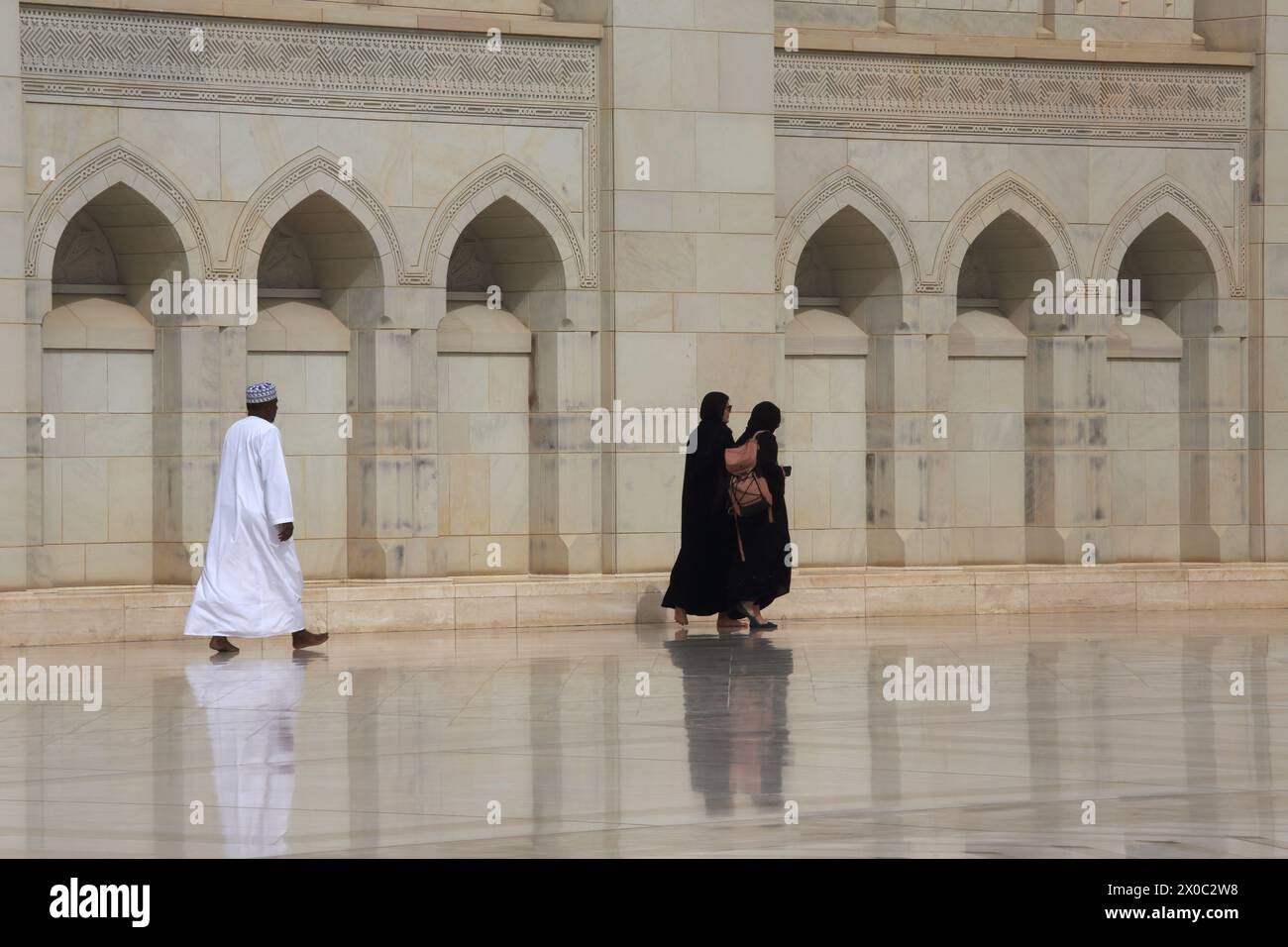 Sultan Qaboos Grand Mosque Besucher in Traditional Dress man Omani Mann trägt Kummah und Dschungdasha und Frauen tragen den Abaya Muscat Oman Stockfoto
