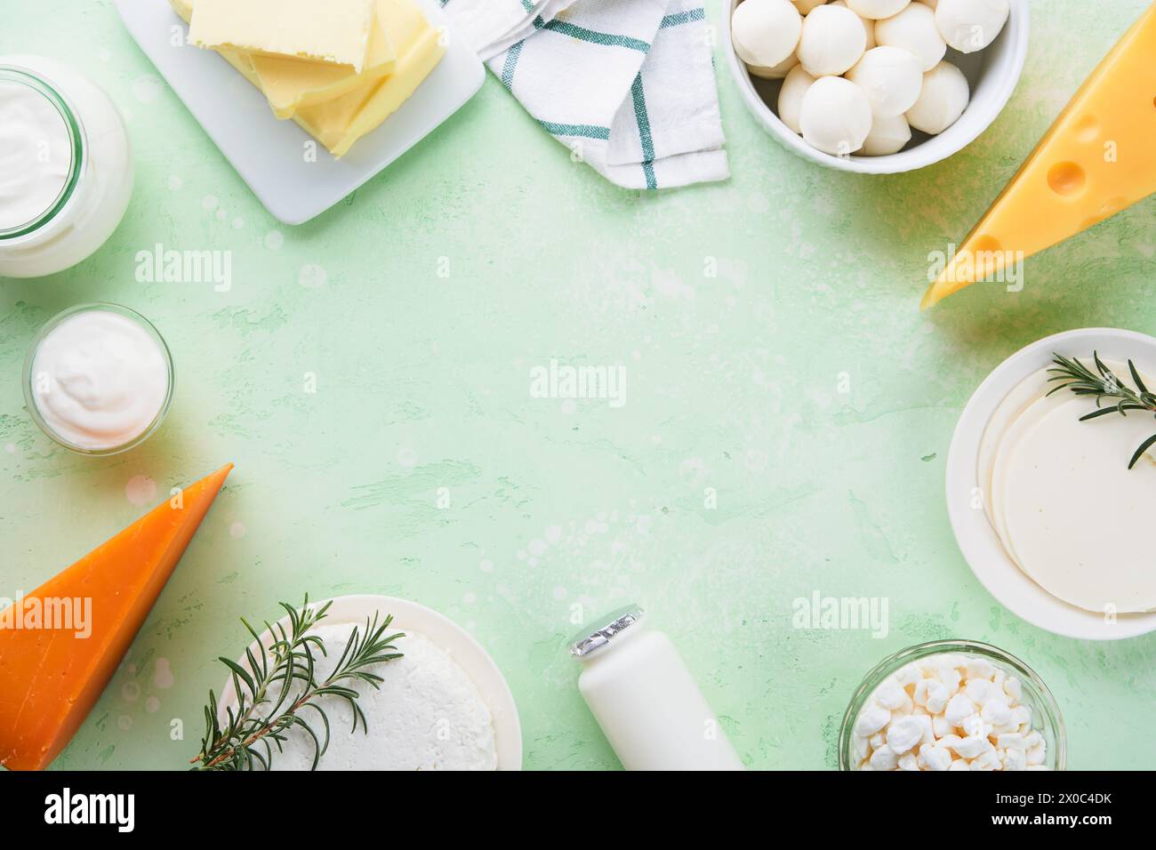 Milcherzeugnisse oder landwirtschaftliche Erzeugnisse. Frische Bio-Milchprodukte Milch, Hüttenkäse, Butter, Sahne, Joghurt, Sauerrahm und Mozzarella auf einem hellgrünen Stockfoto