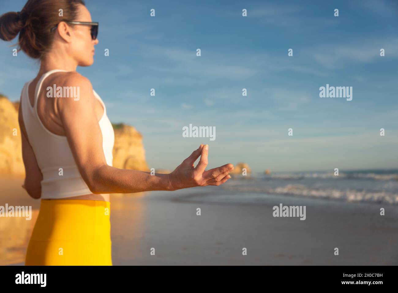 Frau, die inneren Frieden findet und am Strand meditiert. Stockfoto