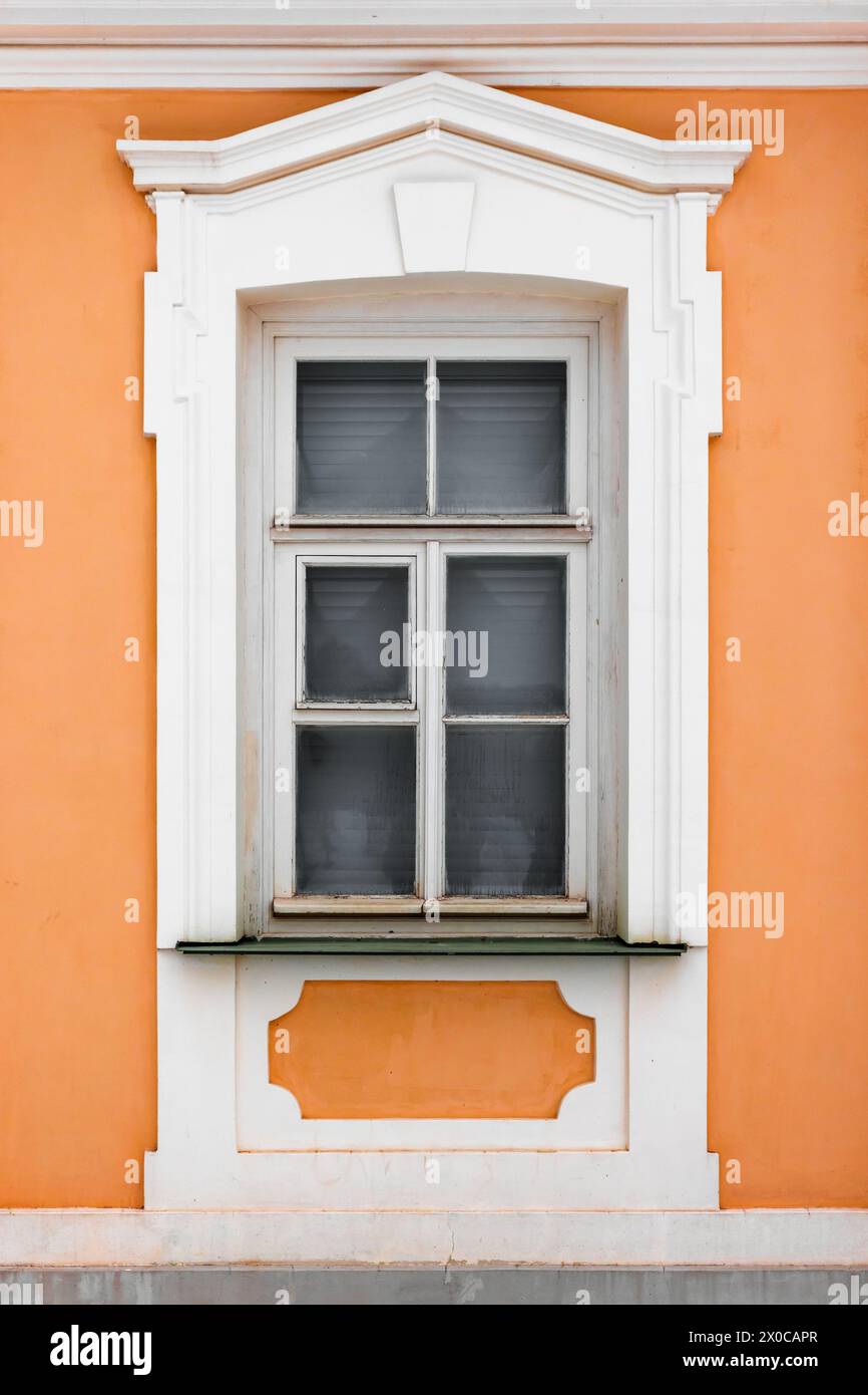 Fenster mit weißem Holzrahmen in alter gelber Steinmauer. Klassische Architekturdetails, Hintergrundfotostruktur Stockfoto