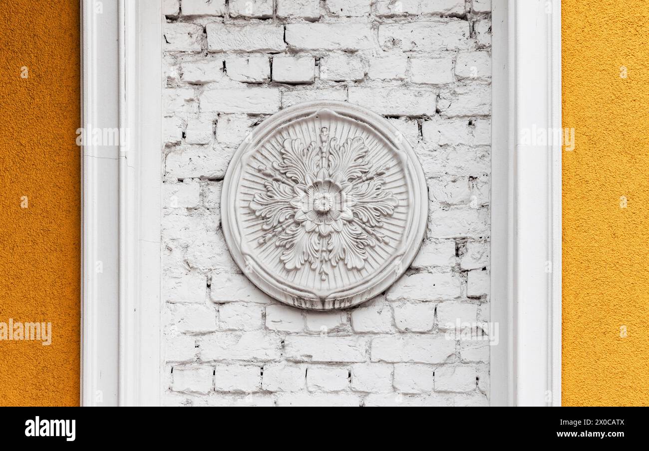 Klassische Architekturdetails, weißes rundes Dekorationselement auf Backsteinwand, Vorderansicht Stockfoto