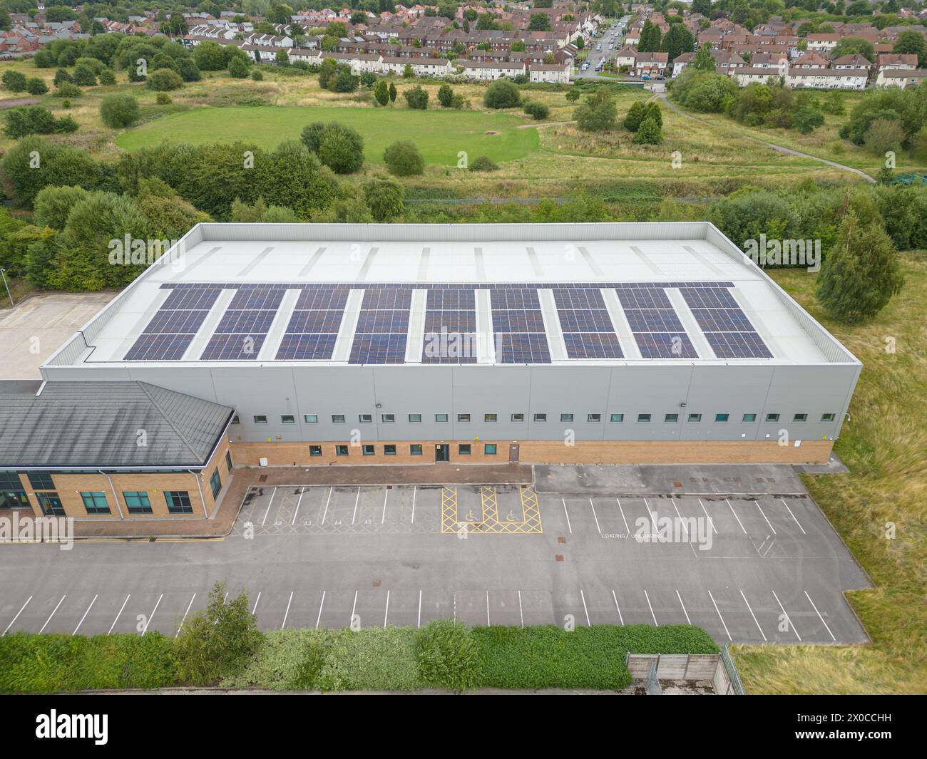 Installation von Solarpaneelen auf dem Dach eines kleinen Industriegebäudes in der Nähe von Manchester, Großbritannien Stockfoto