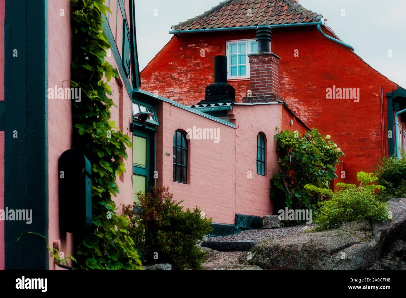 Rotes Haupthaus mit rosa Anbau Stockfoto
