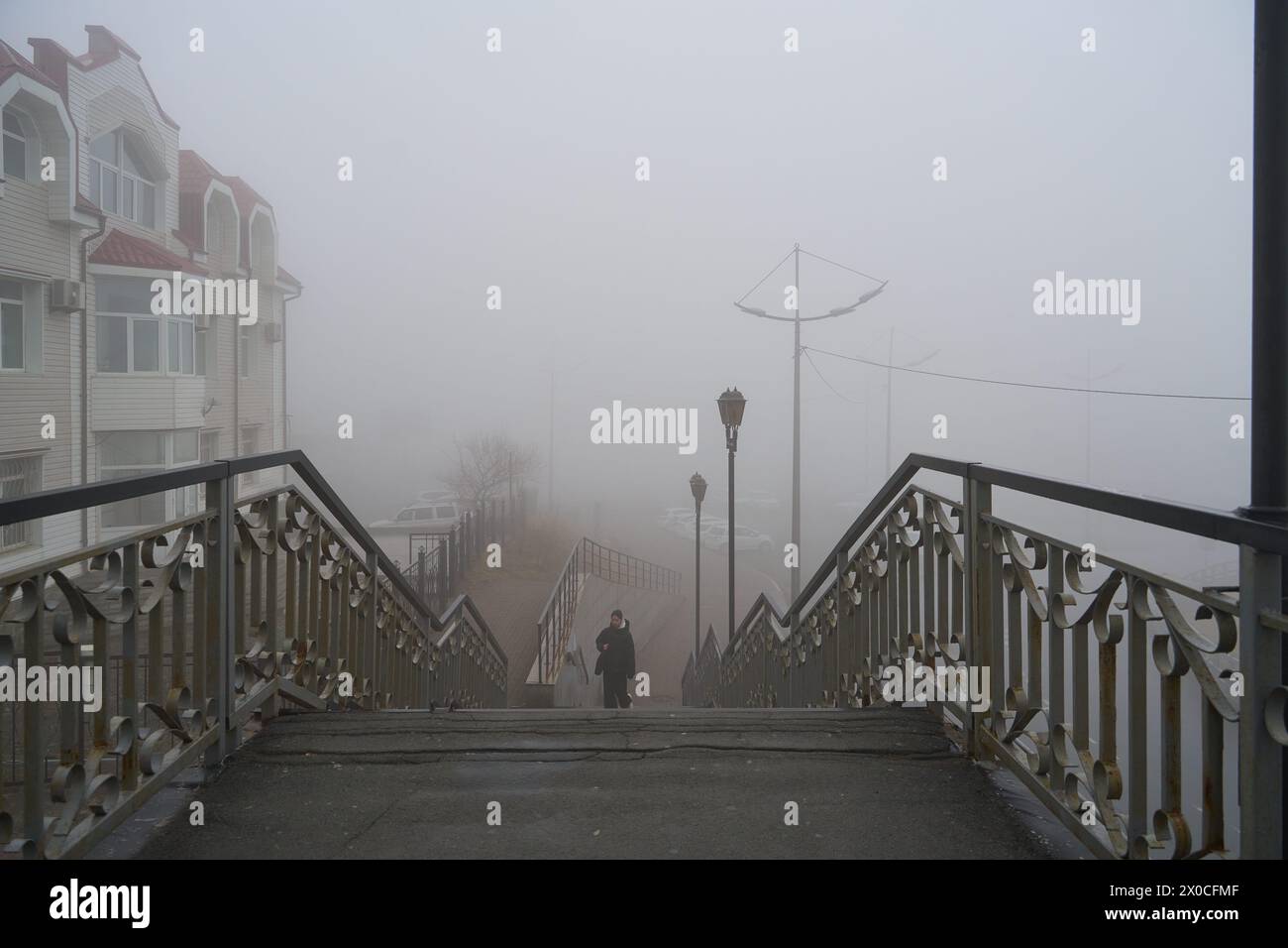 Wladiwostok, Russland. April 2024. Eine Person läuft auf einer Straße unter dichtem Nebel in Wladiwostok, Russland, 11. April 2024. Guo Feizhou/Xinhua/Alamy Live News Stockfoto