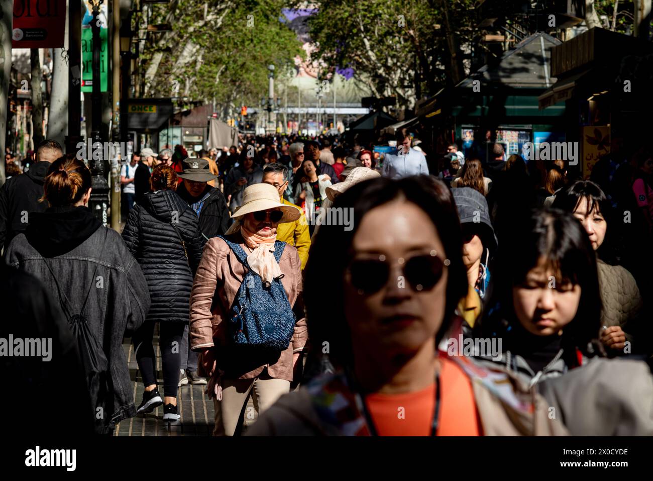 Die Menschen laufen an der Rambla in Barcelona vorbei, einem der wichtigsten Boulevards der Welt und Ziel von Millionen von Touristen und Passanten pro Jahr. Stockfoto