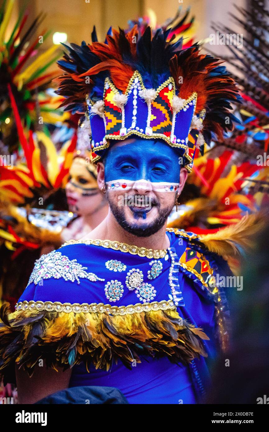 Karneval in Valletta, Malta, Mann mit blauem Gesicht und gefiedertem Kopfschmuck Stockfoto