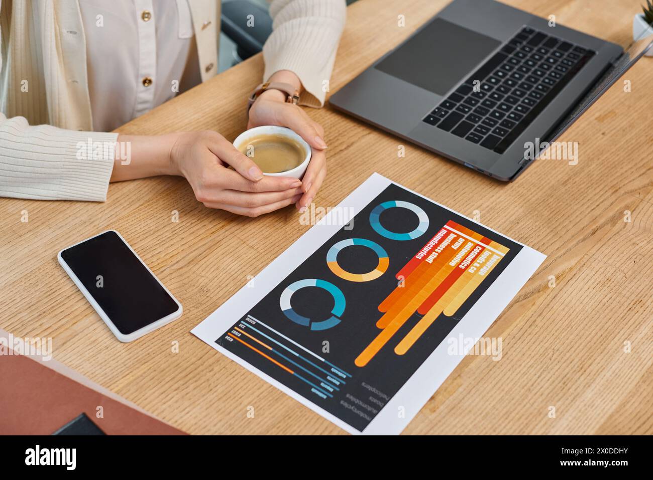 Eine Geschäftsfrau, die tief in Gedanken an einem Tisch sitzt und eine Tasse Kaffee in einem modernen Büroarbeitsplatz serviert. Stockfoto