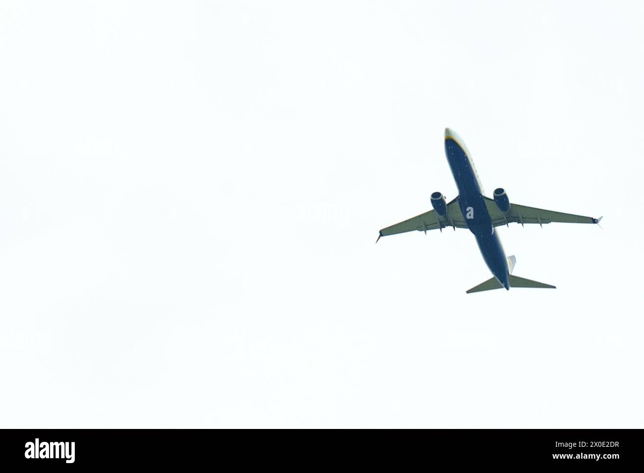 Ein blau-weißes Flugzeug schwebt durch den Himmel und hinterlässt eine Wolkenspur. Stockfoto