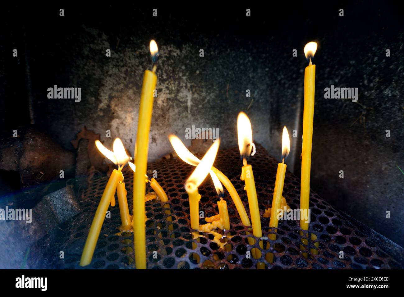 Brennende Kerzen auf serbischem Friedhof mit Flammen, beleuchtet mit Gebet für die Verstorbenen, selektiver Fokus mit geringer Schärfentiefe Stockfoto