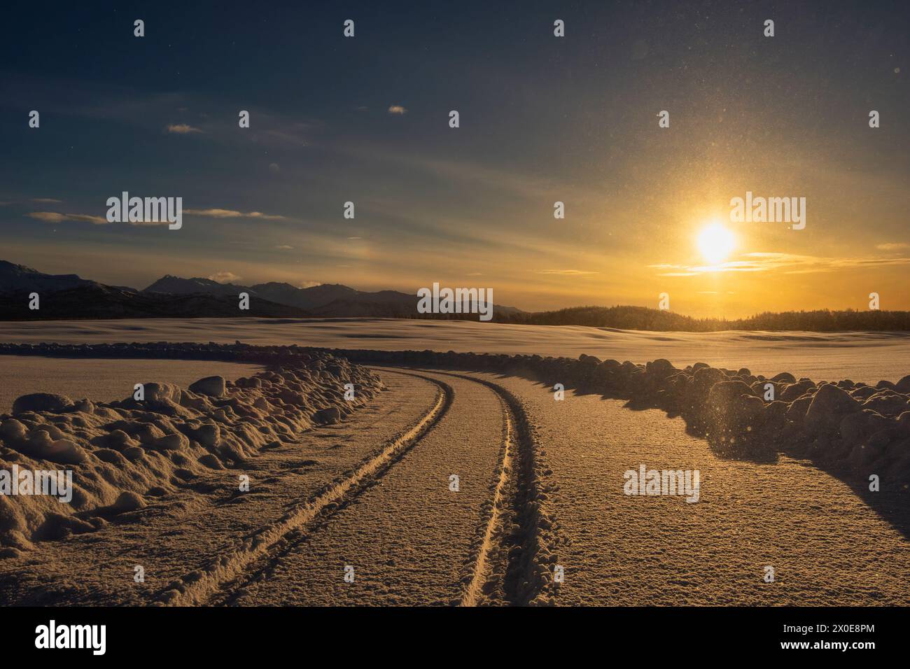 Die niedrige Wintersonne erleuchtet die Chugach Mountains entlang einer Straße im Südwesten Alaskas. Stockfoto