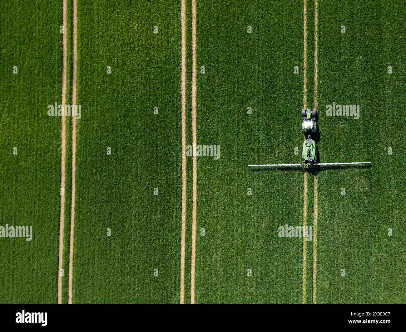 Rottweil, Deutschland. April 2024. Ein Landwirt fährt einen Traktor über ein Feld und sprüht Pestizide. (Luftaufnahme mit einer Drohne). Quelle: Silas Stein/dpa/Alamy Live News Stockfoto