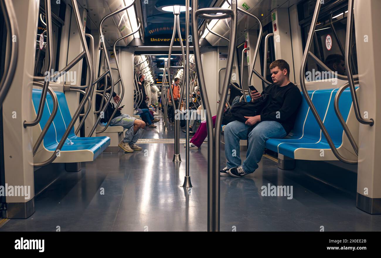 Ein Reisender in einer U-Bahn, der sein Handy ansieht. Stockfoto