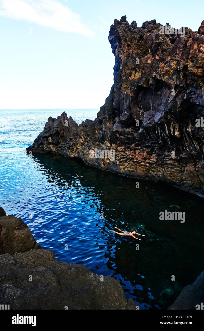 Frau schwimmt durch die Küste von Porto Moniz in Madeira, Portugal, Europa Stockfoto