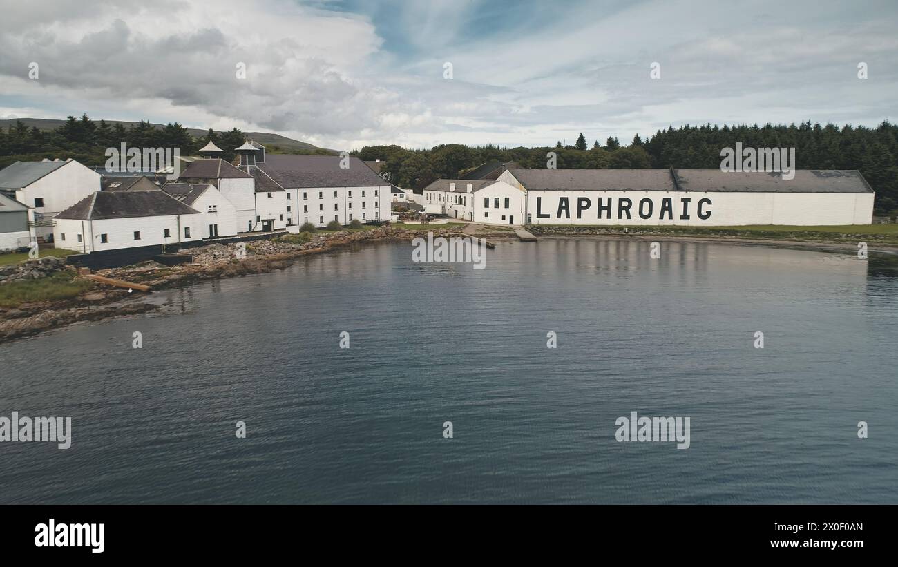 2018.08.07: Laphroaig Whiskey Destillerie, Port Town Ellen, Islay Island, Vereinigtes Königreich, Europa. Alkoholindustrie. Fabrik in Seascape. Industriegebäude, Lagerhaus am Ufer der Meeresbucht Stockfoto