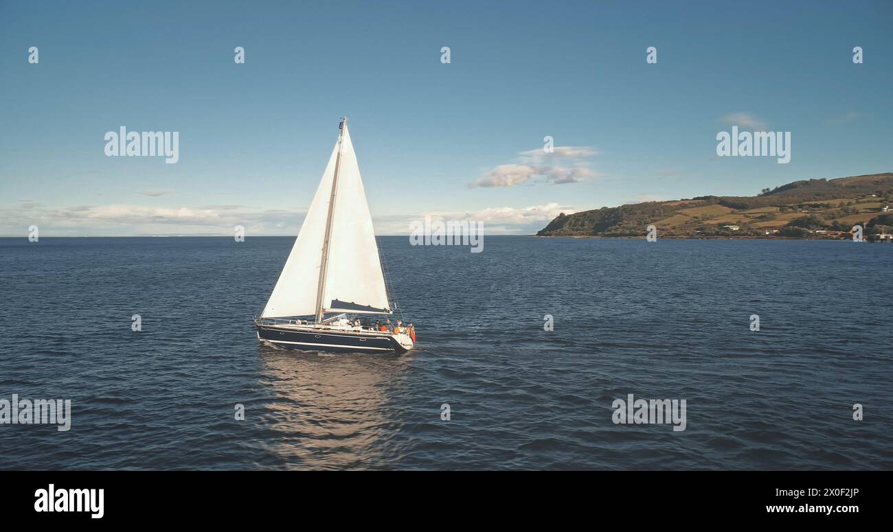 Yachting an Ocean Harbour Aerial. Regatta auf einer Luxusyacht. Segelboote fahren auf offener See. Brodick Port, Arran Island, Schottland. Naturlandschaft am Sommertag. Filmdrohnenaufnahme Stockfoto