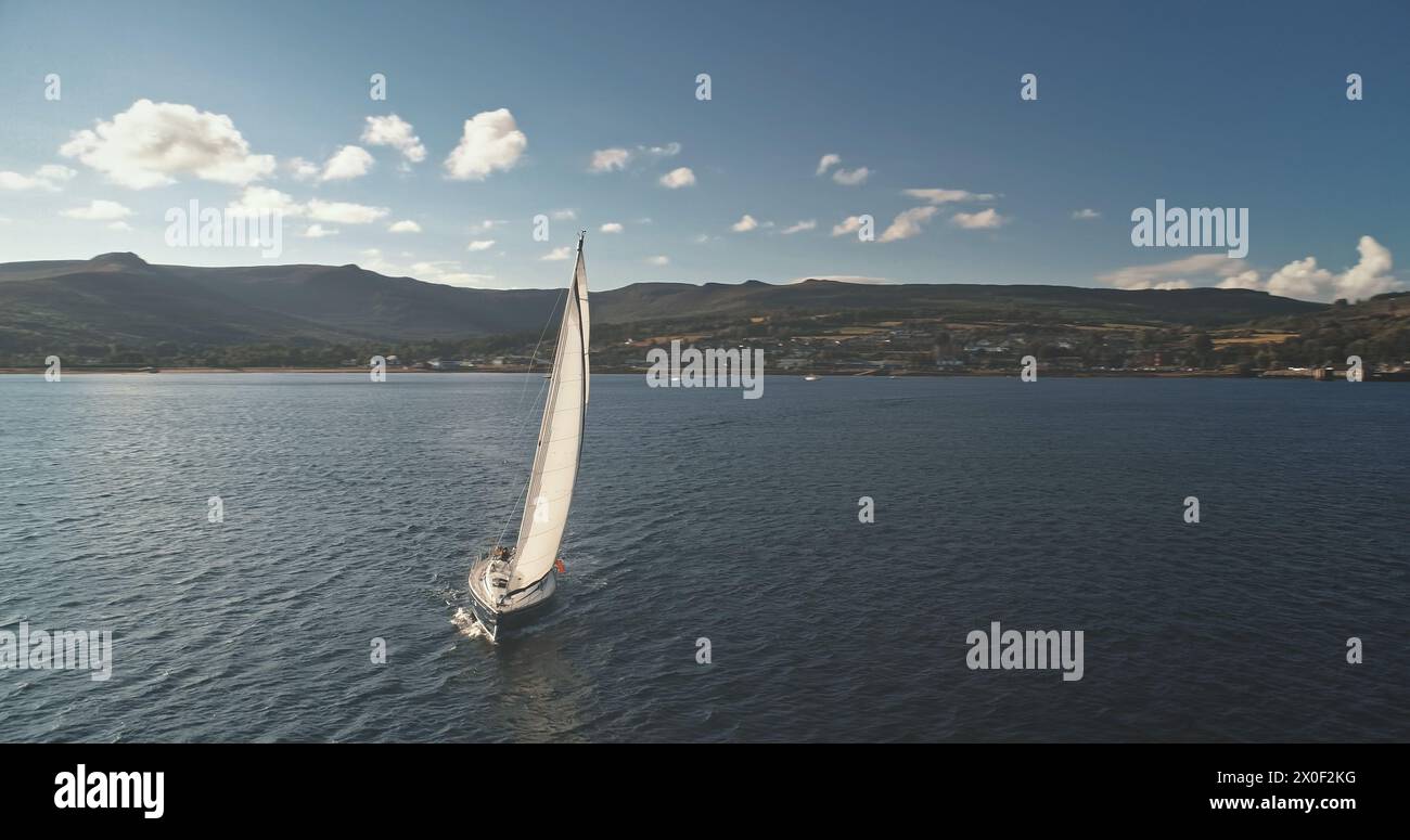 Segeln auf der Meereshafen-Luft. Naturlandschaft am Sommertag. Regatta auf einer Luxusyacht. Segelboote fahren auf offener See. Brodick Port, Arran Island, Schottland. Filmdrohnenaufnahme Stockfoto