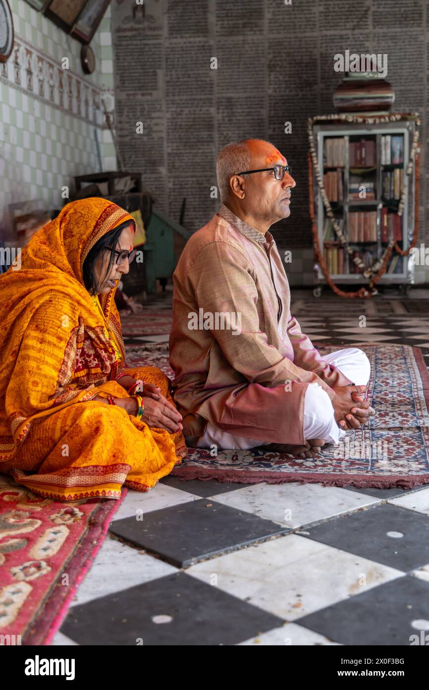 Ein geweihtes Paar betet für den heiligen Gott am Morgen im Tempel aus flachem Winkel Stockfoto
