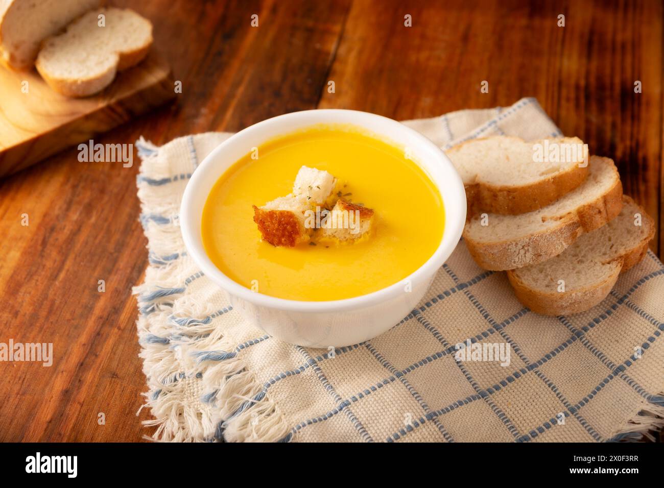 Hausgemachte Karotten- und Kürbiscremesuppe. Einfaches, nahrhaftes und gesundes Rezept. Serviert in einer weißen Schüssel mit Brotcroutons. Perfekt für jeden Tag Stockfoto