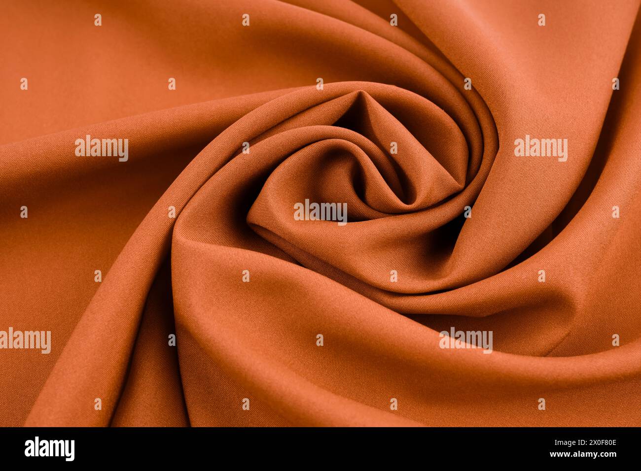 Nahaufnahme abstrakter textiler Hintergrund von dunkelbraunen gefalteten Falten aus Stoff, direkt darüber. Stockfoto