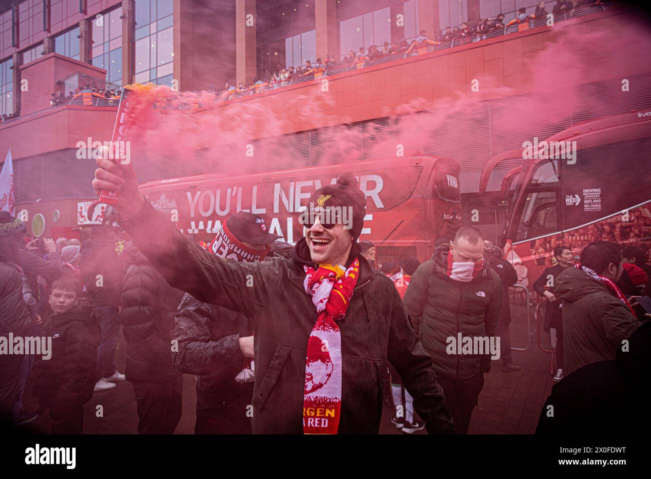 Ein Unterstützer der LFC , der vor dem Spiel der Premier League zwischen Liverpool FC und Manchester City in Anfield eine Rauchgranate in die Hand hält . Stockfoto