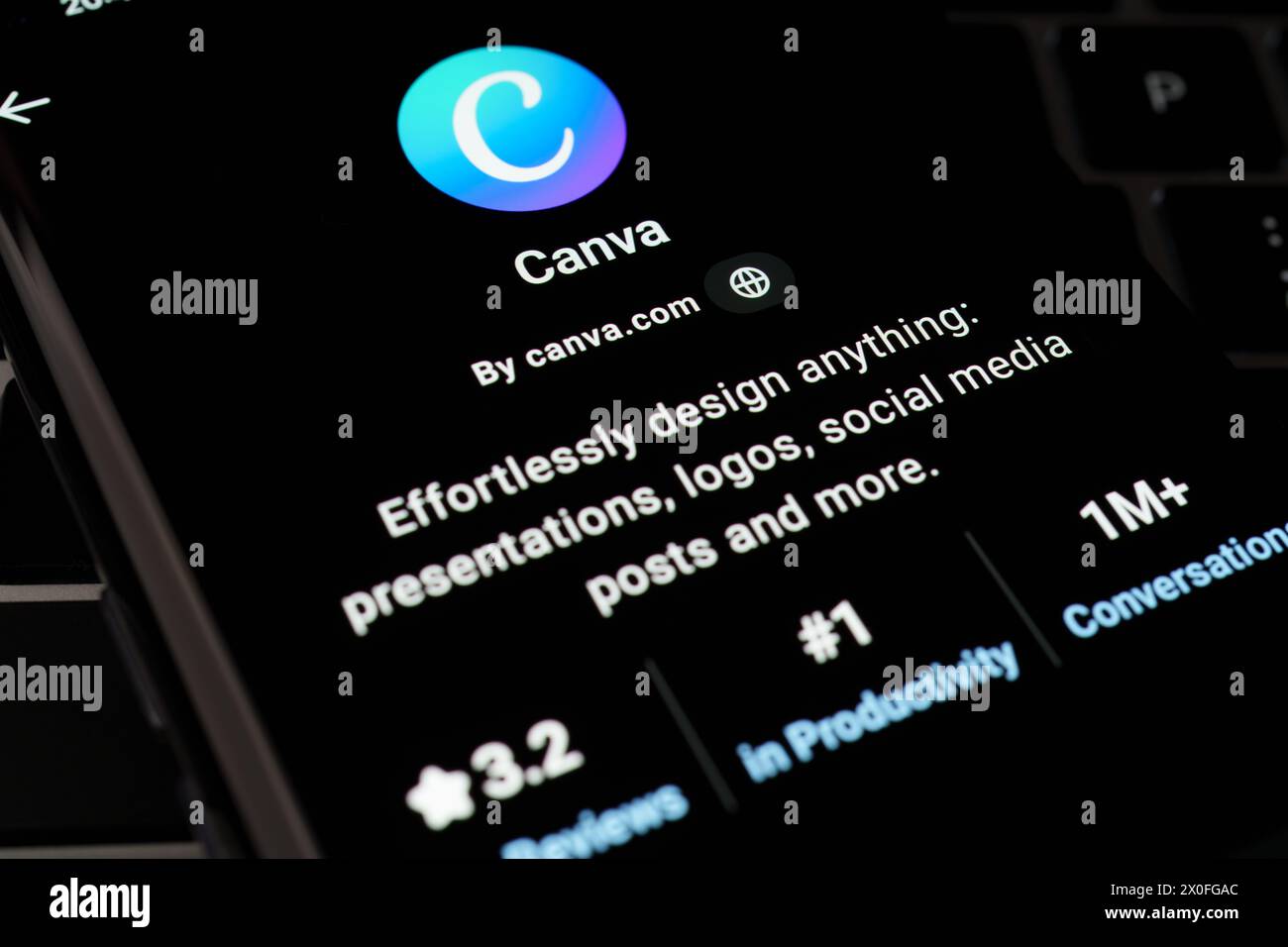 CANVA Custom GPT wird im GPT Store auf dem Bildschirm des Smartphones angezeigt, das auf der Tastatur des Laptops platziert ist. Stafford, Vereinigtes Königreich, 8. April 2024 Stockfoto