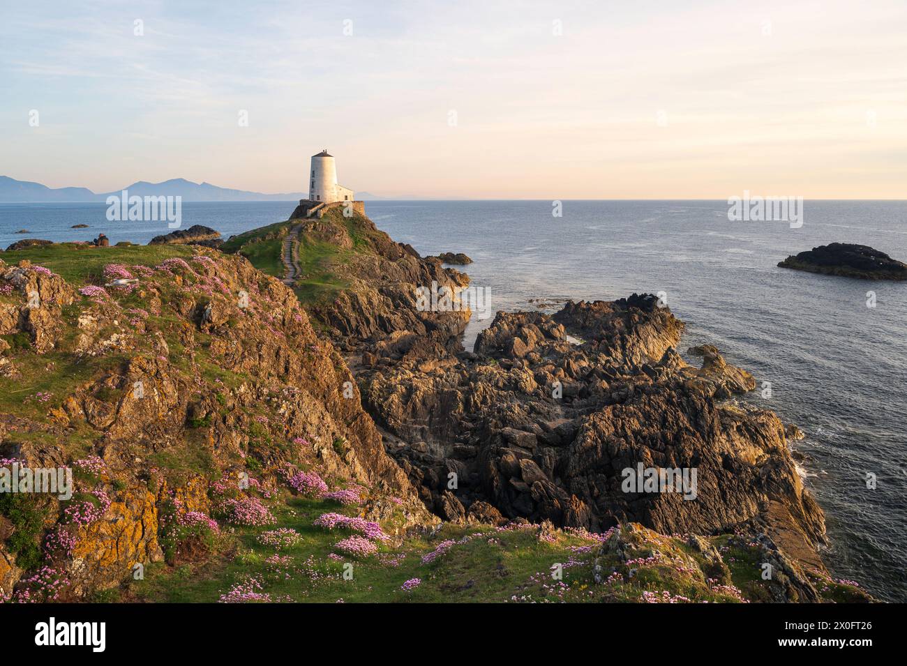 Der majestätische TWR Mawr Leuchtturm bei Sonnenuntergang auf der Insel Ynys Llanddwyn in Anglesey, Nordwales. Stockfoto