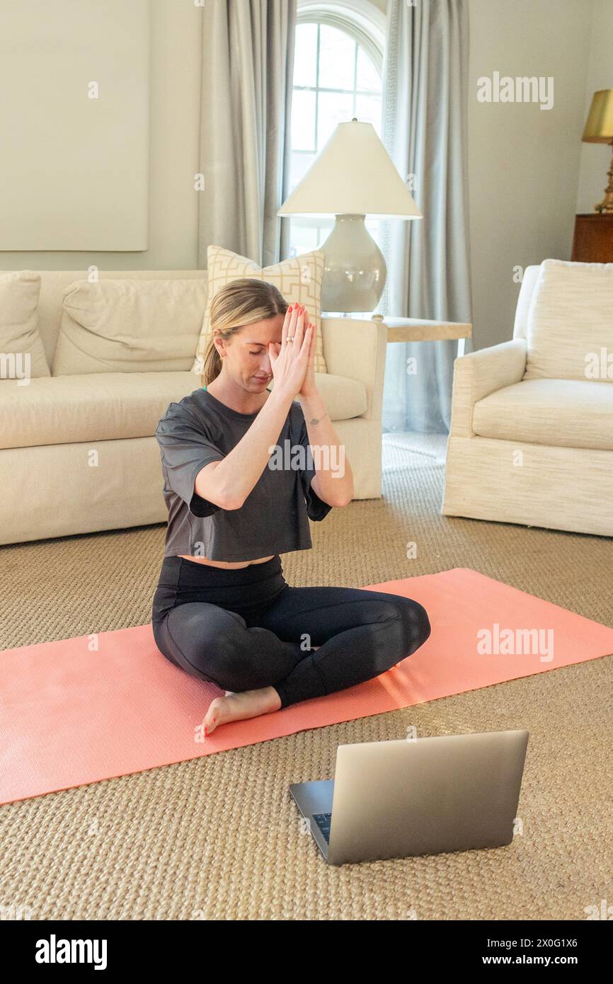 Frau, die online Yoga zu Hause macht Stockfoto