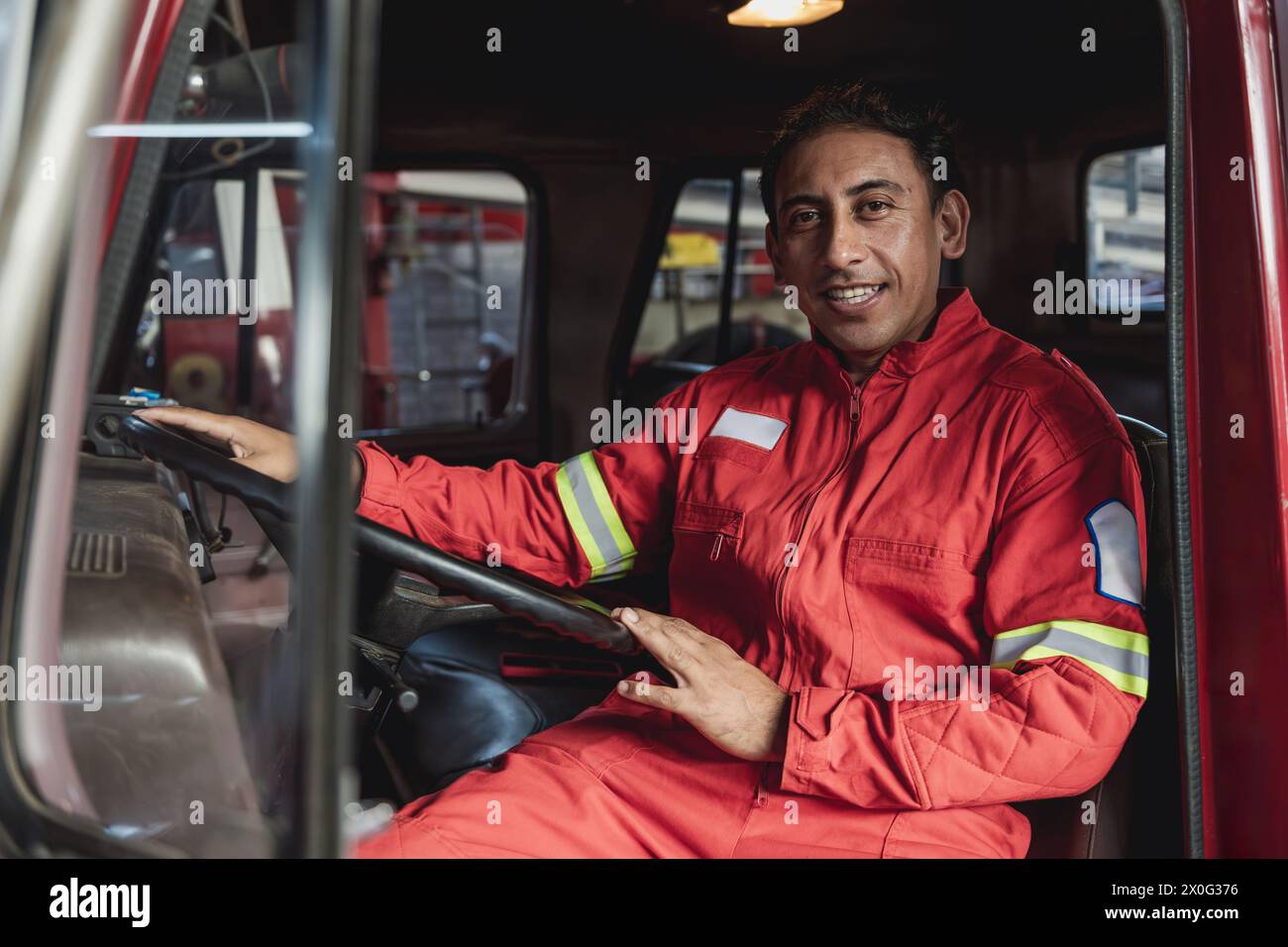 Porträt eines Feuerwehrwagenfahrers, der auf der Feuerwache lächelt Stockfoto