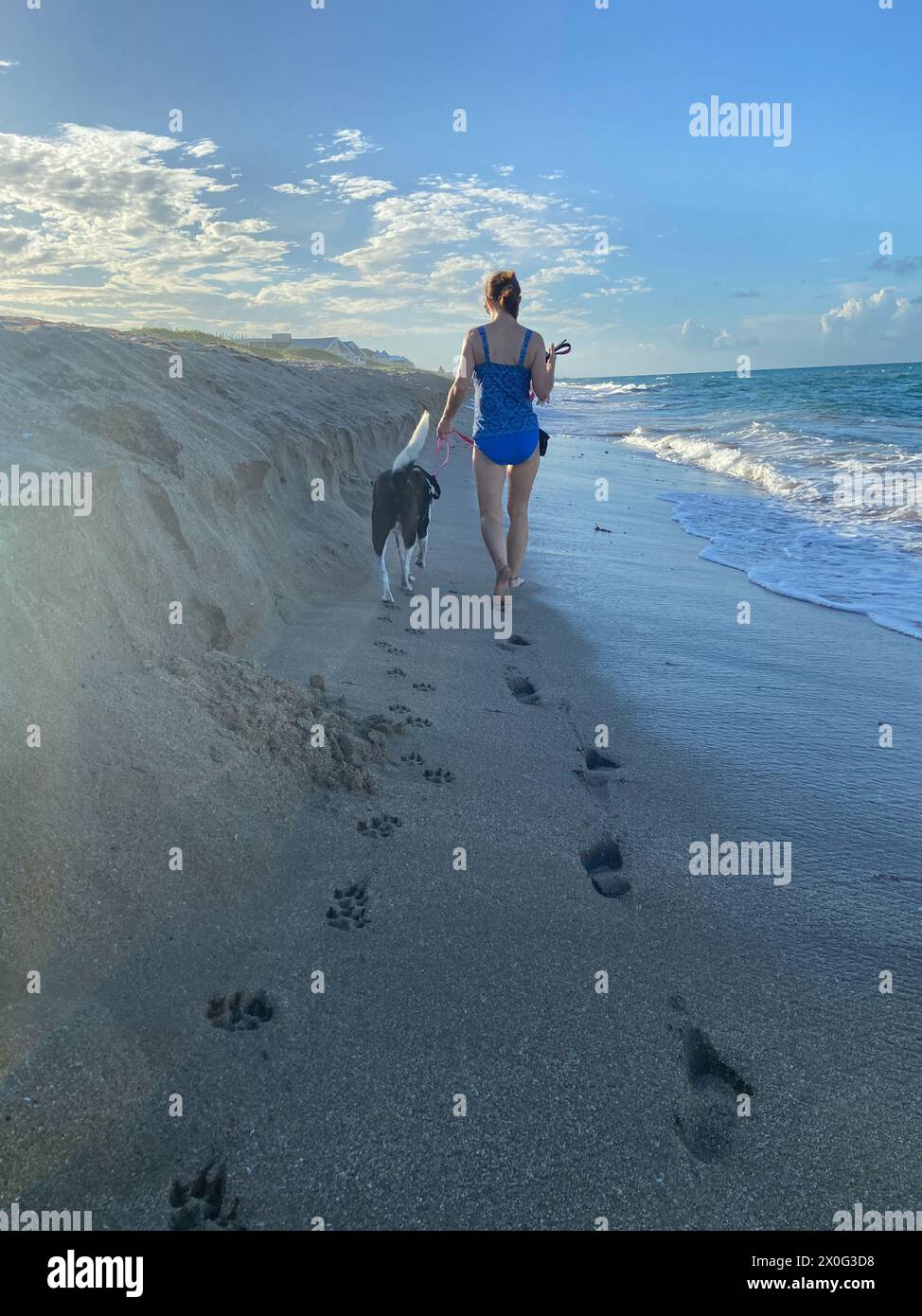 Fußabdrücke und Fußabdrücke im Sand von einer Frau, die am Strand herumläuft Stockfoto